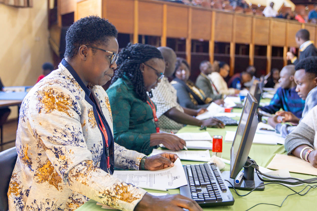 A Kenyan school administrator reviewing digital records on a laptop