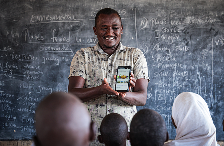 A Kenyan teacher using a smartphone